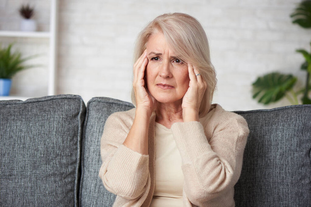 Idős nő szenved fejfájás vagy depresszió grimaszoló fájdalom  - Fotó, kép