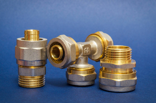 Three brass fittings is often used to connect for water and gas installations on blue background - Foto, afbeelding