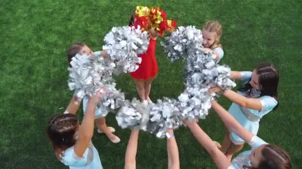 Cheer leaders teenage girls in uniform shaked pom poms, support sport team in college - Footage, Video