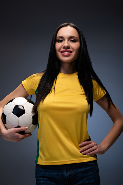 beautiful smiling girl holding football ball on grey - Photo, Image