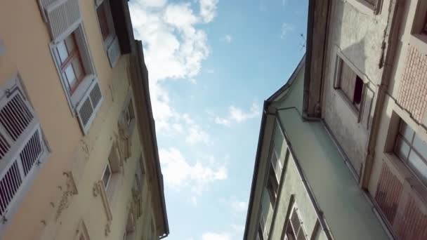 pohled zdola nahoru na tradiční domy ve Freiburgu, Německo. Procházím se po malé staré ulici a dívám se po střechách. Tradiční německé střechy. Slunečný den. - Záběry, video