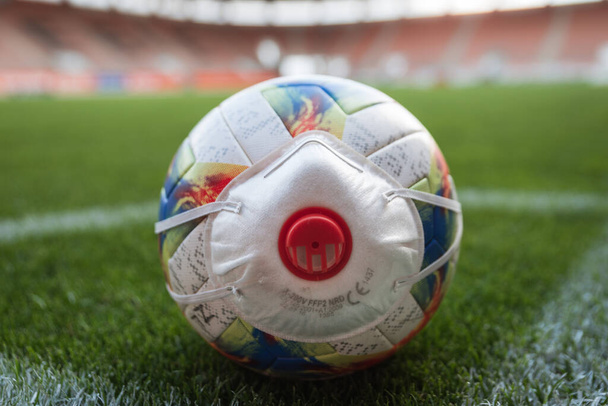 Η μπάλα με μάσκα (σύμβολο coronavirus) στη γωνία του γηπέδου ποδοσφαίρου - Φωτογραφία, εικόνα