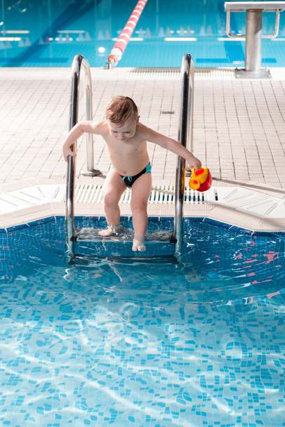 cute toddler boy with toy climbing pool ladder  - Foto, Imagem