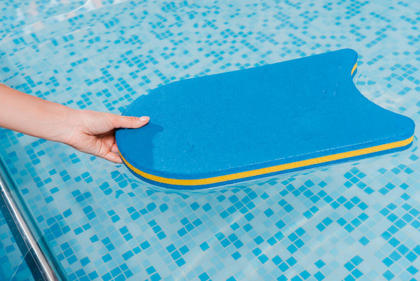 cropped view of woman touching flutter board in swimming pool  - Fotoğraf, Görsel