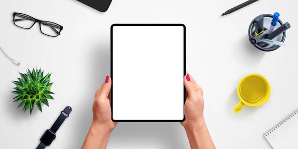 Tablet in woman hands with isolated screen for app or web site design presentation mockup. Top view, flat lay composition - Photo, Image
