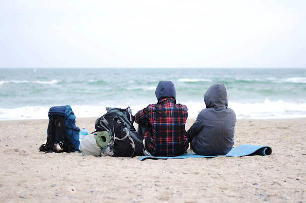 Denizin kenarında iki adam sahilde oturuyor. En iyi tatil. Mavi gökyüzü ve deniz geçmişi.. - Fotoğraf, Görsel