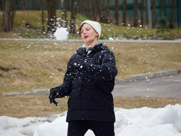 Diversão de inverno. adolescente alegre em um chapéu joga bolas de neve 2020
 - Foto, Imagem