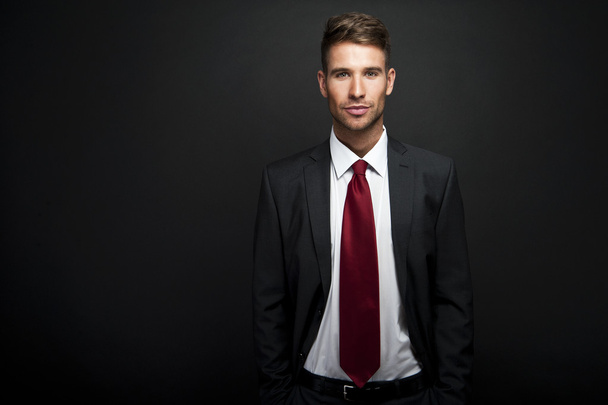 Empresário em pé sobre fundo gradiente escuro
 - Foto, Imagem