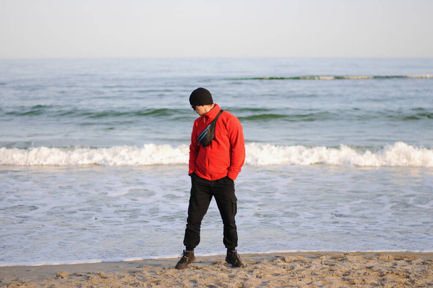 Ein Mann steht bei schlechtem Wetter gegen das Meer. - Foto, Bild