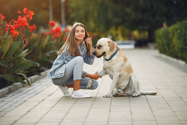 Girl walking in a spring sity with cute dog - Foto, immagini