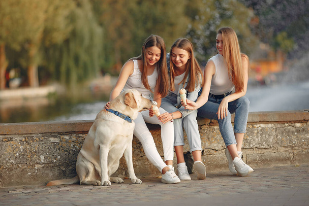 Girls sitting in a spring sity with cute dog - Fotoğraf, Görsel