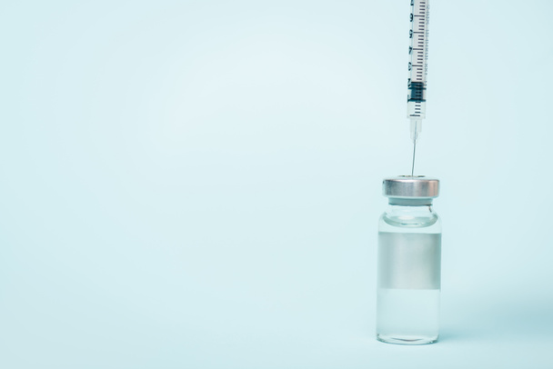 Spritze im Glas Impfstoff mit Hormon auf blauer Oberfläche mit Kopierraum - Foto, Bild