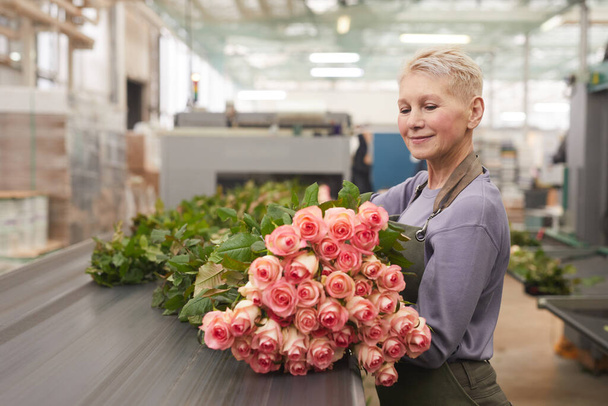 Woman with roses in warehouse - 写真・画像