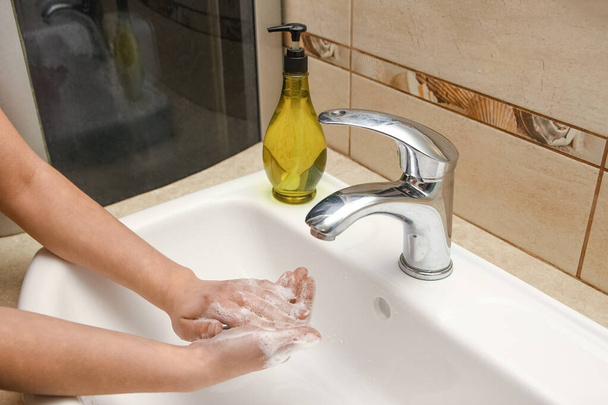 Πλένει τα χέρια με σαπούνι κάτω από τη βρύση με νερό - Φωτογραφία, εικόνα