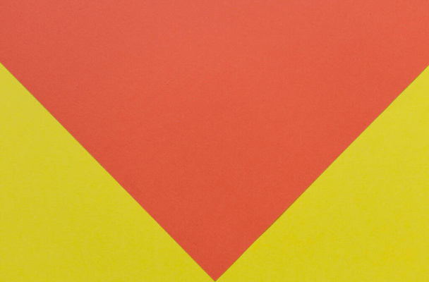Bright yellow and red cardboard background, with the yellow part forming two triangles on the bottom - Photo, image
