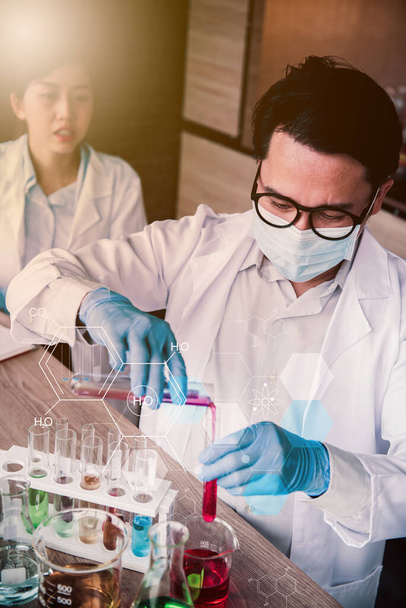 Scientist team has researching and working on Coronavirus cure in the laboratory. Asian Doctor examining samples and applying a vaccine against virus infection. - Photo, image