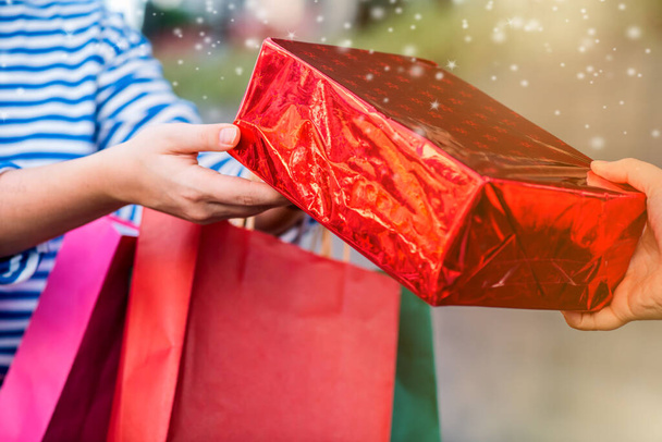 közeli felvétel nő kezében színes bevásárló táskák karácsonyi ajándékok - Fotó, kép