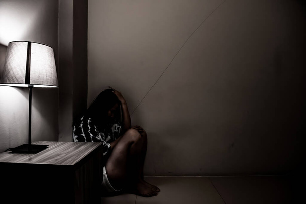 Femme dépressive seule dans la chambre noire. Problème de santé mentale, le TSPT est un trouble de stress post-traumatique. - Photo, image