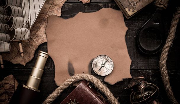 Columbus Day. Vintage worldmap and discovery equipment. Copy space on dark wood background. - Photo, Image
