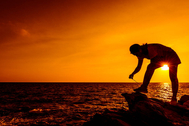 Sylwetka kobieta ćwiczenia na plaży zachód słońca. Sport i zdrowy styl życia. - Zdjęcie, obraz