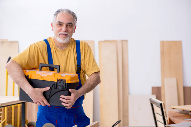 Yaşlı erkek marangoz atölyede çalışıyor. - Fotoğraf, Görsel