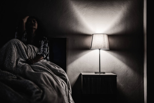 Masennus nainen yksin pimeässä huoneessa. Mielenterveysongelma, traumaperäinen stressihäiriö. - Valokuva, kuva