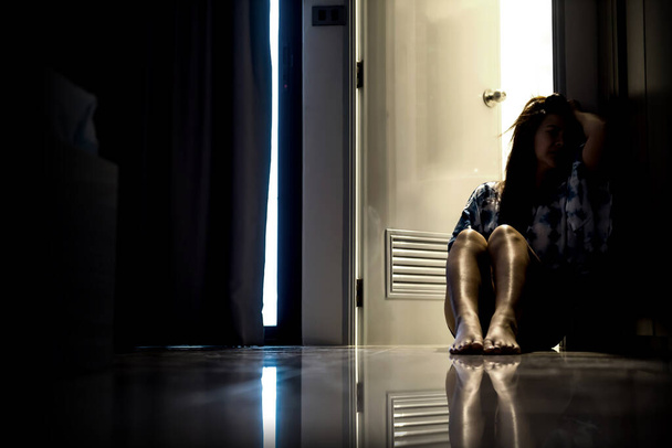 Depressziós nő egyedül a sötét szobában. Mentális egészségügyi probléma, poszttraumás stressz zavar. - Fotó, kép