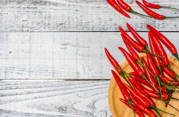 Hot and spicy red chili peppers on wooden table background - Foto, imagen