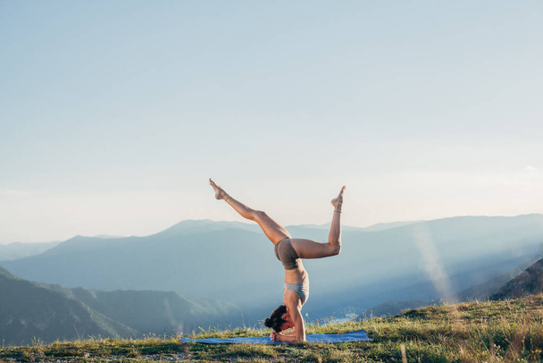 Fit junges Mädchen praktiziert Yoga bei Sonnenuntergang - Foto, Bild