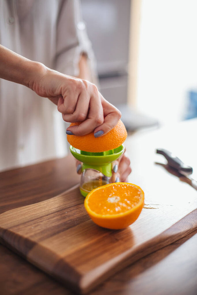 台所でオレンジジュースを作る女性 - 写真・画像