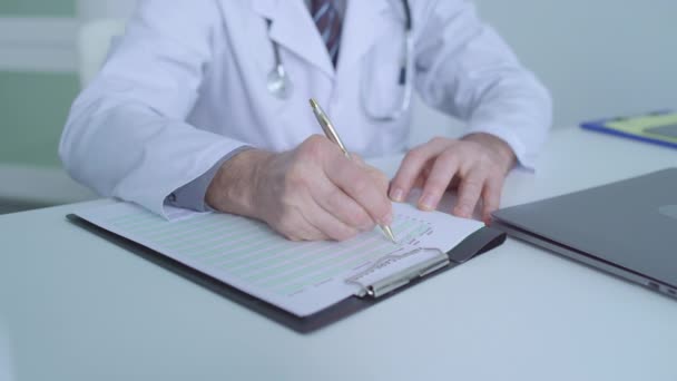 Doctor writing in medical document, filling out healthcare insurance papers - Video