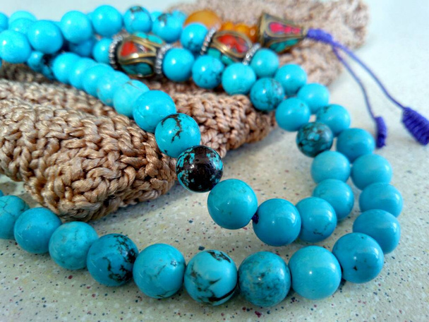 Tibetan turquoise rosary with brown handmade knitted cover in macro photo - Photo, Image
