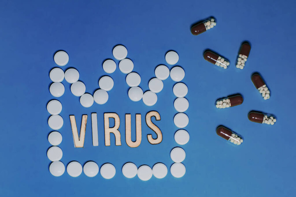 Text Virus. White tablets lined in shape of crown symbolizing Novel Coronavirus outbreak concept. 2019-nCoV virus infection originating in Wuhan, China - Foto, imagen