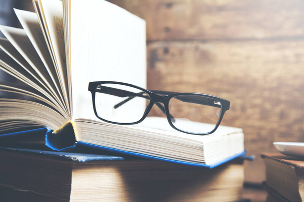 glasses on books on wooden table background  - Photo, image