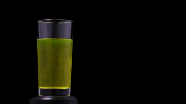 Vitamin C tablet dissolves in transparent glass on black background with copy space - Footage, Video