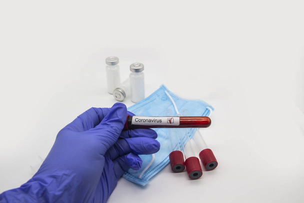 コロナウイルスの血液検査2019.コロナウイルスは中国武漢から来ました。検査室でコロナウイルス陽性血液と医療用手袋保持試験管で医師の手。デザインにコンセプトを使用できます。 - 写真・画像