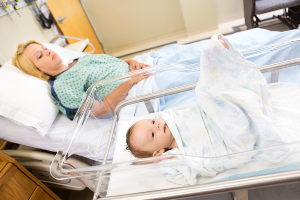 Babygirl Lying In Bassinet With Woman On Hospital Bed - Fotografie, Obrázek