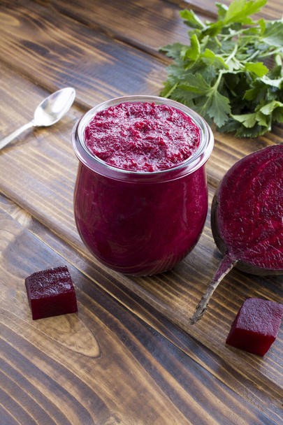 Smoothies or puree with beet in the small glass jar on the brown wooden  background. Location vertical. - Photo, Image