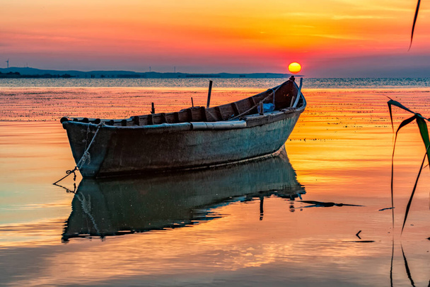 Kaunis auringonnousu veneellä järvellä, Razelm Razim Lake, Sarichioi, Romania
 - Valokuva, kuva