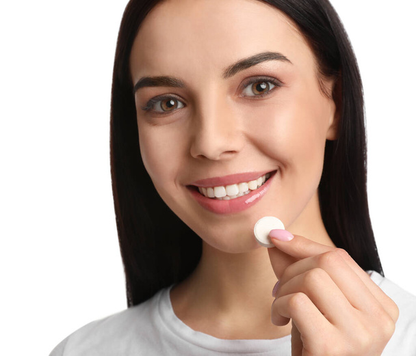 Young woman taking vitamin pill on white background, closeup - Photo, Image