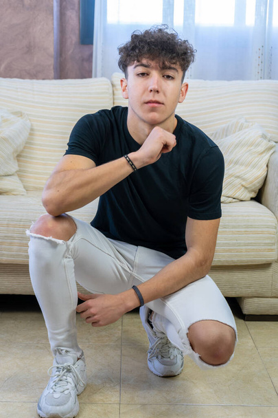 Young man posing on a white sofa in his living room - Photo, image