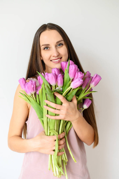 Spring mood. Beautiful woman with tulips indoors - Fotografie, Obrázek