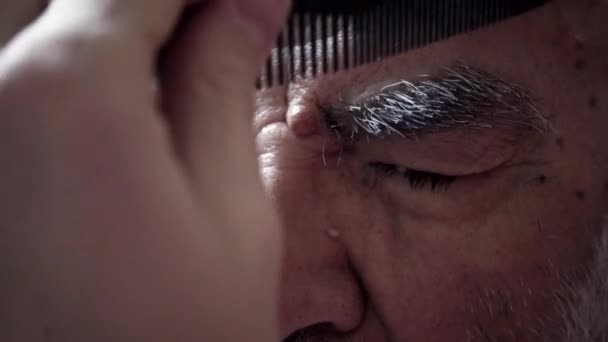 Nahaufnahme eines 80-jährigen älteren türkischen muslimischen Mannes, dessen Augenbrauen in seinem Vintage-Badezimmer aus den 1980er Jahren geschnitten wurden - Filmmaterial, Video