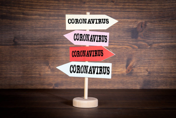 Coronavirus. Señalización con flechas sobre fondo de madera oscura
 - Foto, imagen