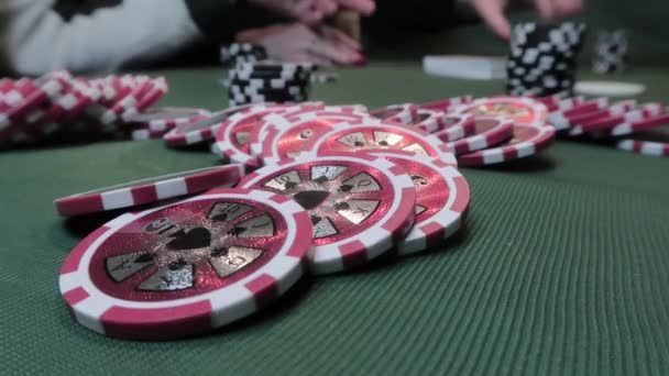 Detailní záběr pokerových žetonů na zelené látce na pozadí hraní pokerových lidí - Záběry, video