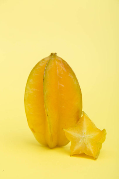 Star fruit carambola or starfruit with slice on yellow background. Healthy fruit food. Tropical fruit. - Photo, Image