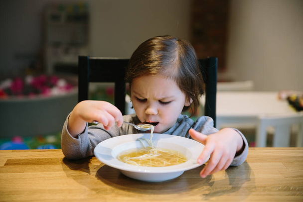 Dziewczynka z miską zupy makaronowej - Zdjęcie, obraz