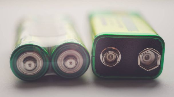 Два різних типи батарей на столі крупним планом
 - Фото, зображення