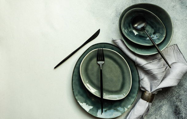 Table setting with modern ceramic dishware and cutlery on grey concrete background with copy space - Foto, Bild