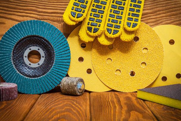 Великий набір абразивних інструментів і жовтих робочих рукавичок на старовинних дерев'яних дошках майстра використовується для шліфування предметів
 - Фото, зображення
